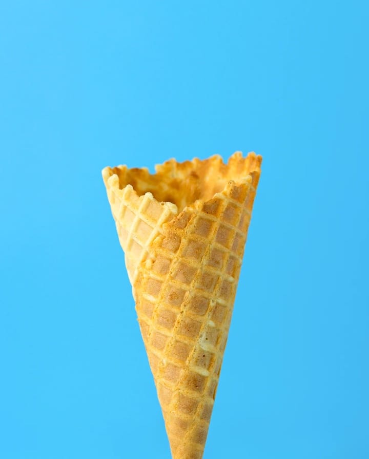 Image of a waffle cone infront of a blue background