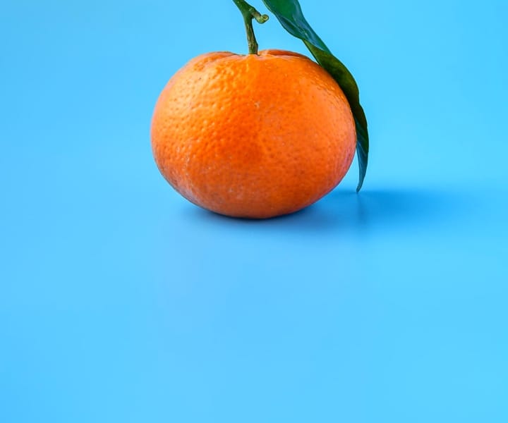 Image of a mandarin placed on a blue surface