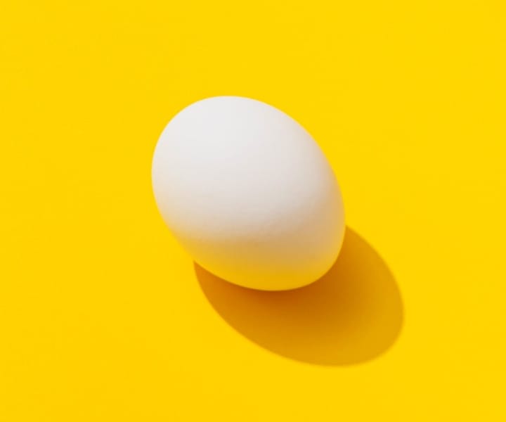 Image of an egg placed on a yellow background